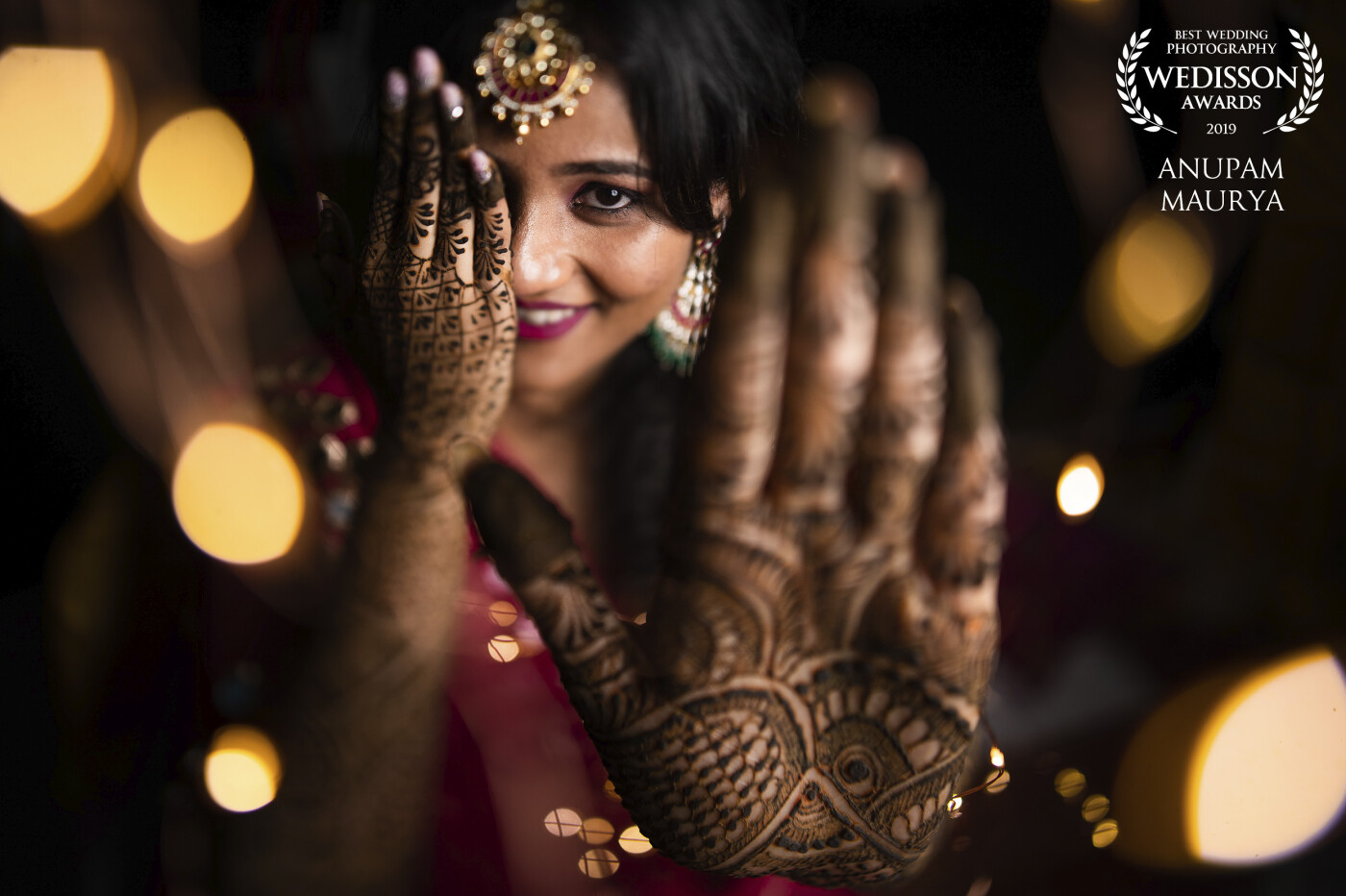 Photographs of henna on the bride's hands often the most cliche photos. I wanted to do something different and better. So I asked her to take out her left hand further ahead to form the foreground and focused on her eyes. At the same time, I used foreground blur using fairy lights and tilt-shift lens for a narrow horizontal focus. The result came out to be stunning and the bride absolutely loved it. I posted this same photo instantly by transferring on my phone from the camera. I knew this was a winner. 