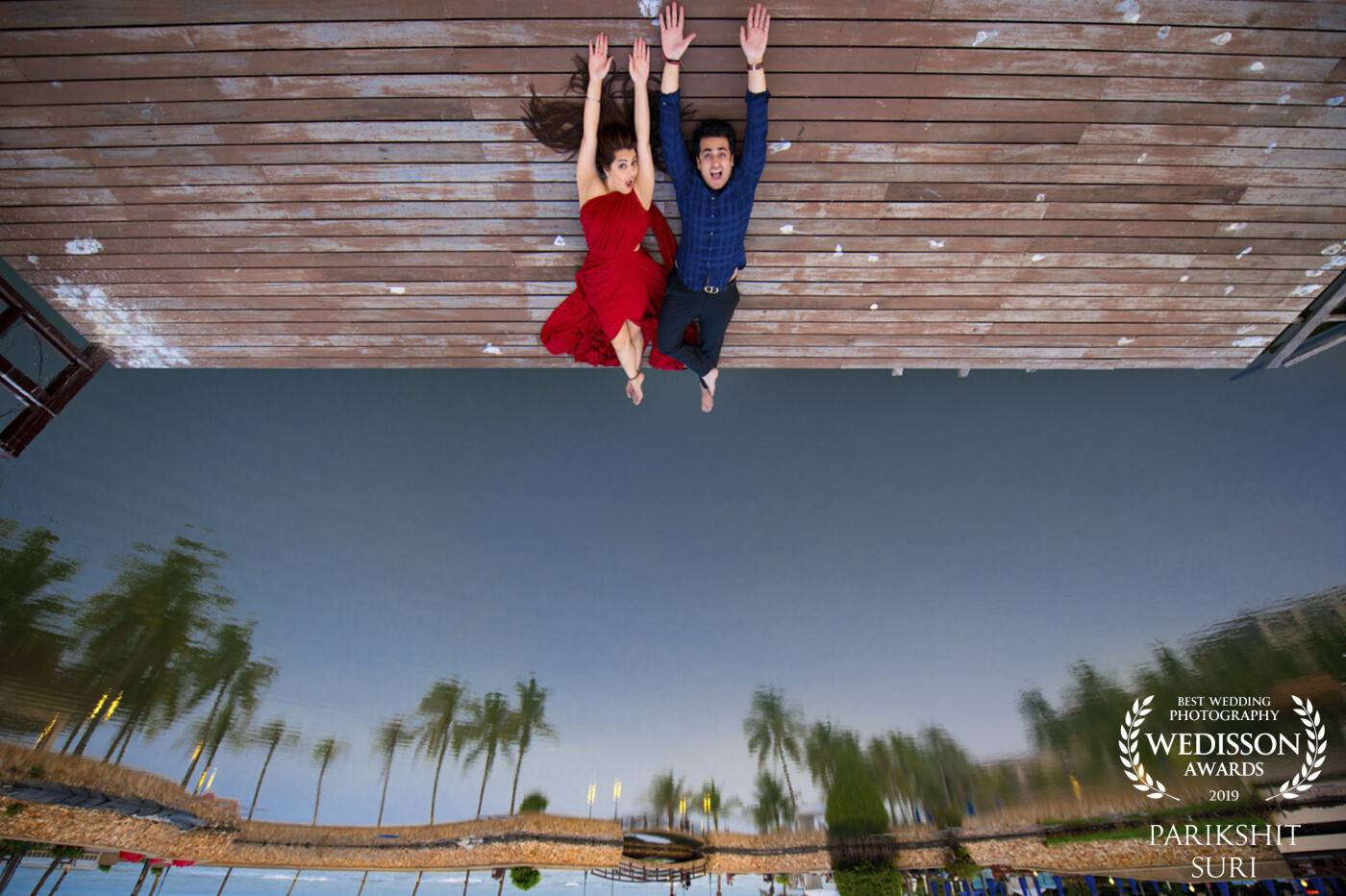 Oops, The Worlds Upside Down!!  When we were shooting this pre-wedding in Hua Hin (Thailand), I saw this deck with the lake in front of it, the reflections of the trees and sky in the water made this the perfect location for this inverted image. 