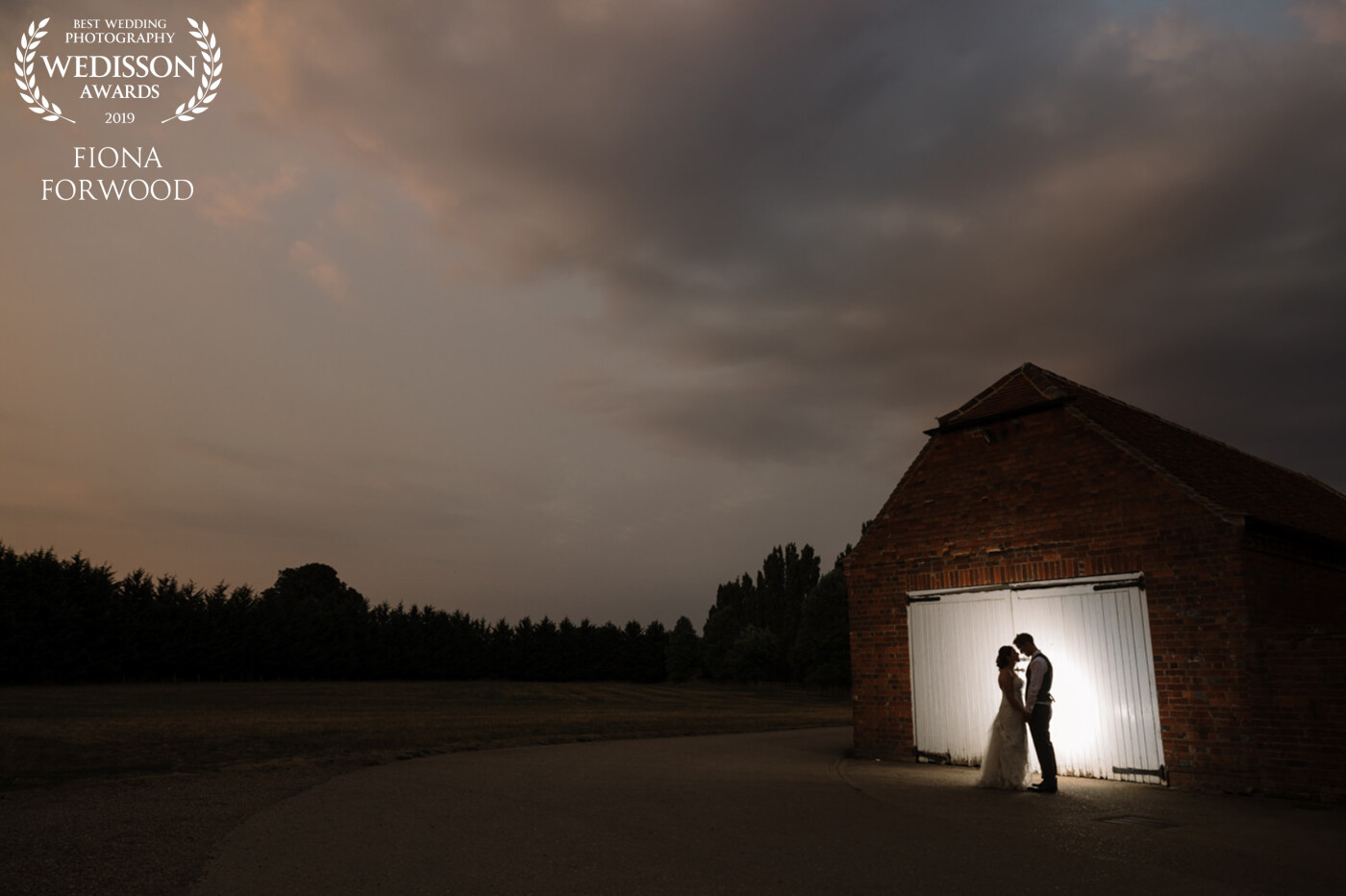 This photo was taken in the evening of a really hot wedding in July at Lillibrooke Manor. The Sky looked pretty and I knew I could do a nice silhouette against the white barn doors. The bride and groom Rosaria and Ben are such a wonderful couple and they were so up for coming away from their evening celebration to get this photo made.