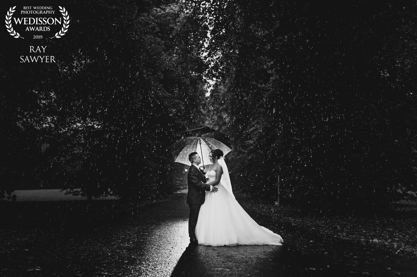 Another rainy day wedding. I took the couple outside just before sunset and completed their couple portraits. For this shot, I placed y AD200 flash about 5-7m behind them with a Grid and Sphere. Backlighting the couple but also backlights the rain and freezes it.