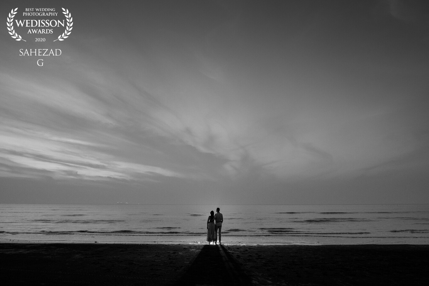 I believe in Taking an image, freezing a moment, reveals how rich reality truly is. On this day, the sun was about to set; it was already getting dark. But I wanted to make a landscape filled with this couple. I have chosen sky shadows over this couple and captured this beautiful picture upon this beach with white sand.