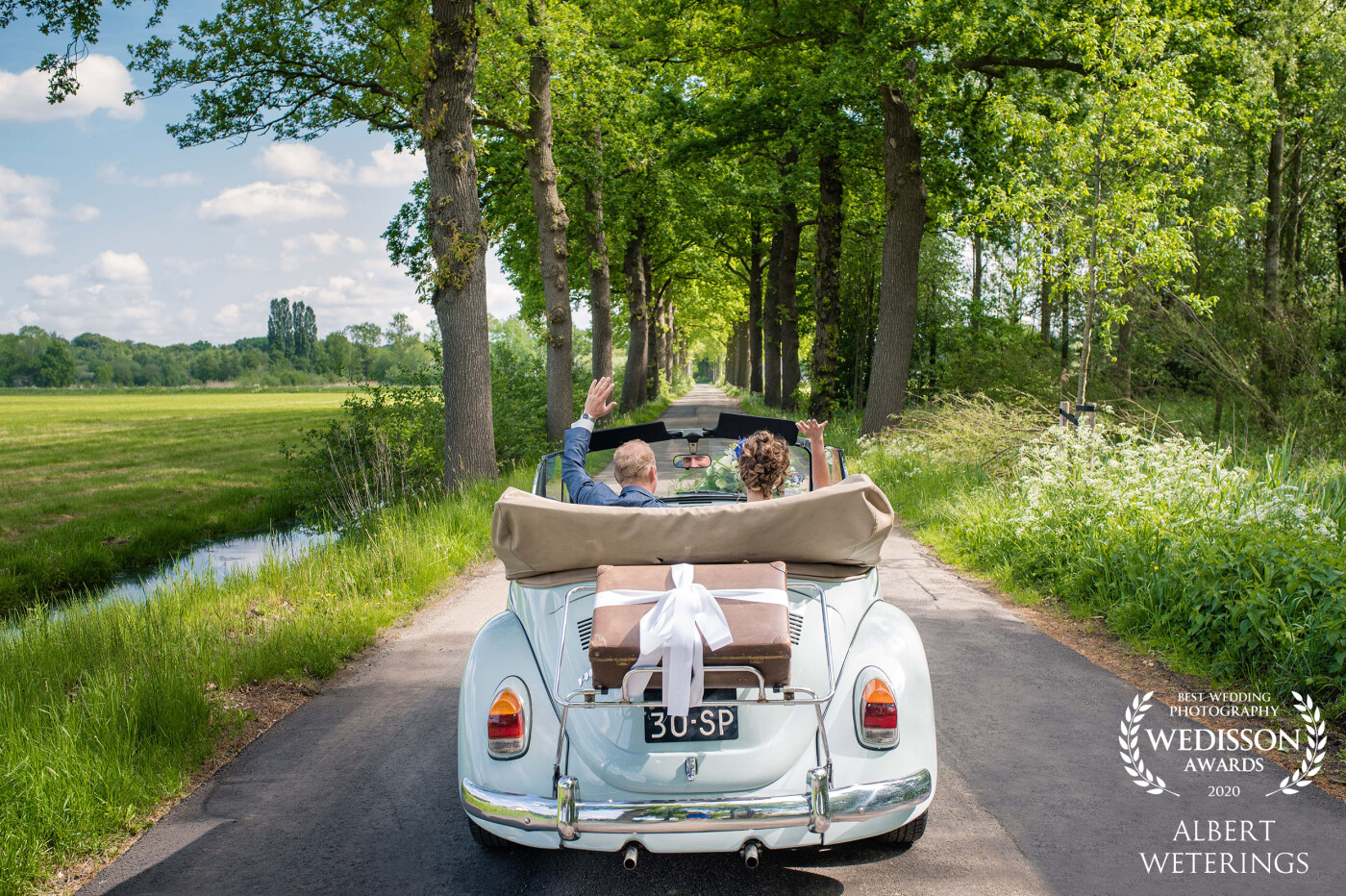 On a lovely summer day, we went to Zeist for the wedding of H&J. They had arranged a lovely old VW Kever (or Beetle) Cabrio as their car for the day. When they drove off from the house of the bride and waved goodbye to the family, we captured this great moment.
