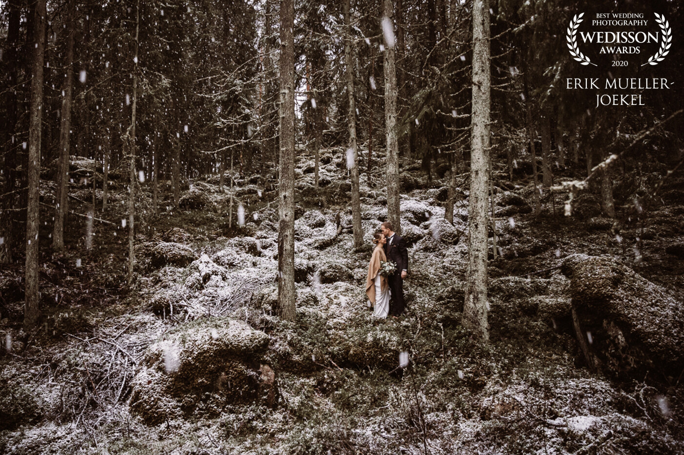 It was raining all day in Finland. But after the wedding, the rain turned into snow and the bride and groom walked fearlessly through the wet moss in the forest. It was a magical wedding photo session in the Finnish woods.