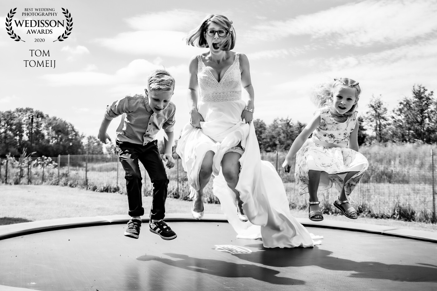 A trampoline brings back the youth in us...The bride in her parent's backyard could not resist doing a jump with her cousin and niece. Fun is a key ingredient for a good wedding/photo. <br />

