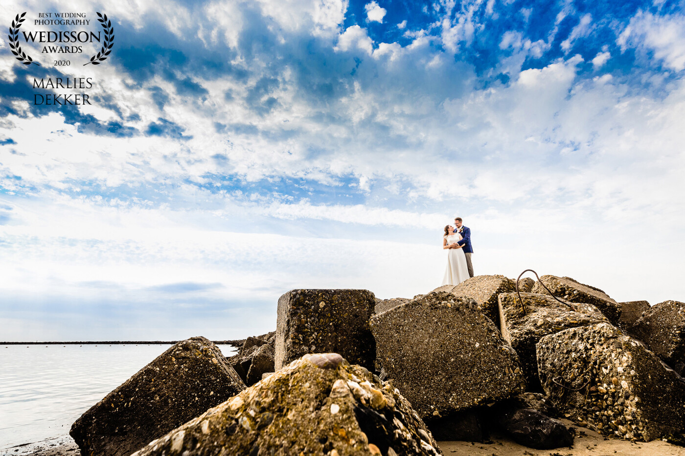 This lovely couple married at the beach. We did a short shoot after their wedding ceremony. We climbed these blocks to make this beautiful picture with these awesome clouds. It was a steep climb for both so I loved the brave nature of the couple, otherwise, I could not make this lovely shot.