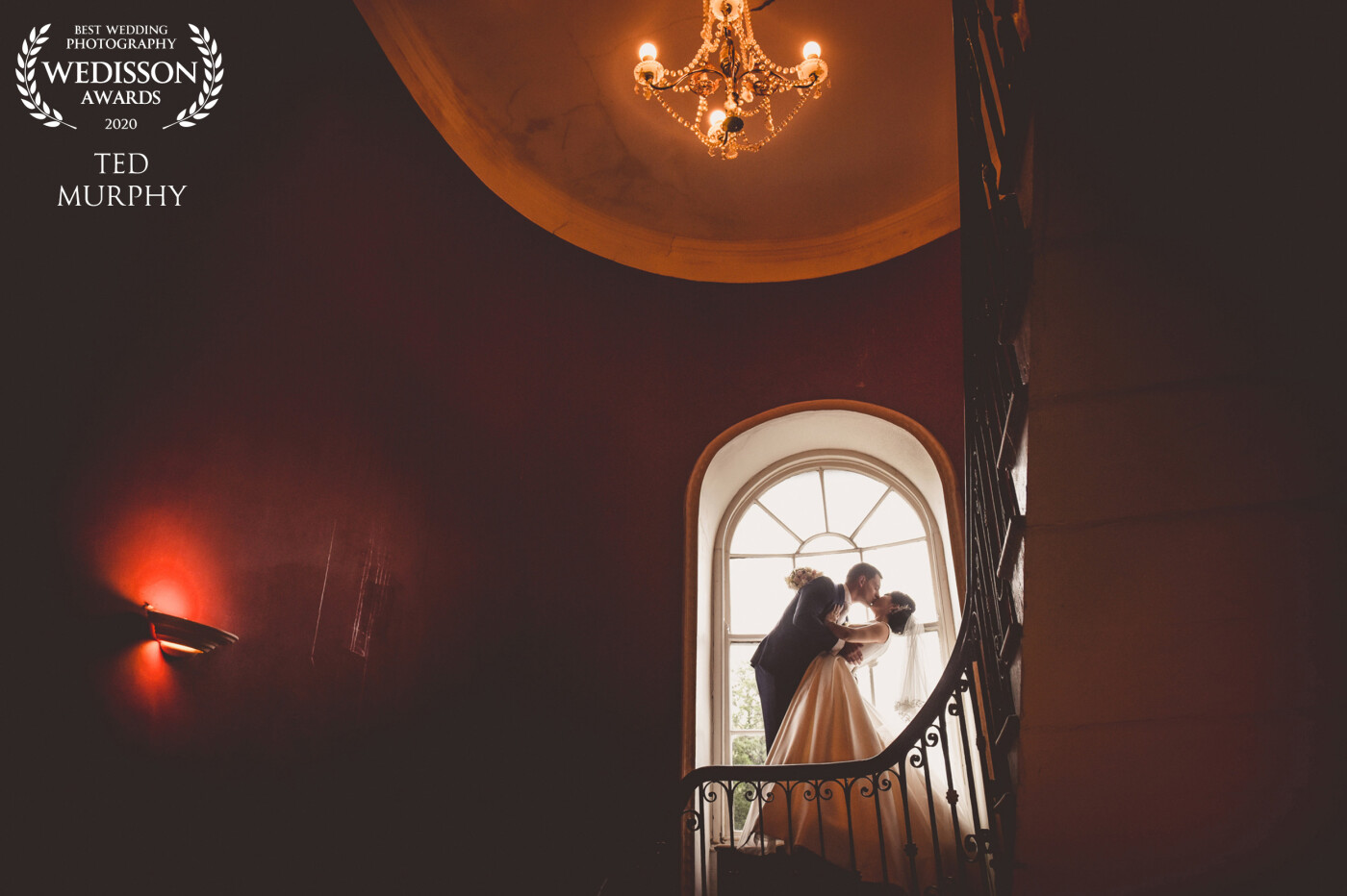 Zhanar and Trevor stood on an old trunk on the staircase to their suite at The Maryborough House hotel. I love all the original features of this Georgian house and the romantic staircase.
