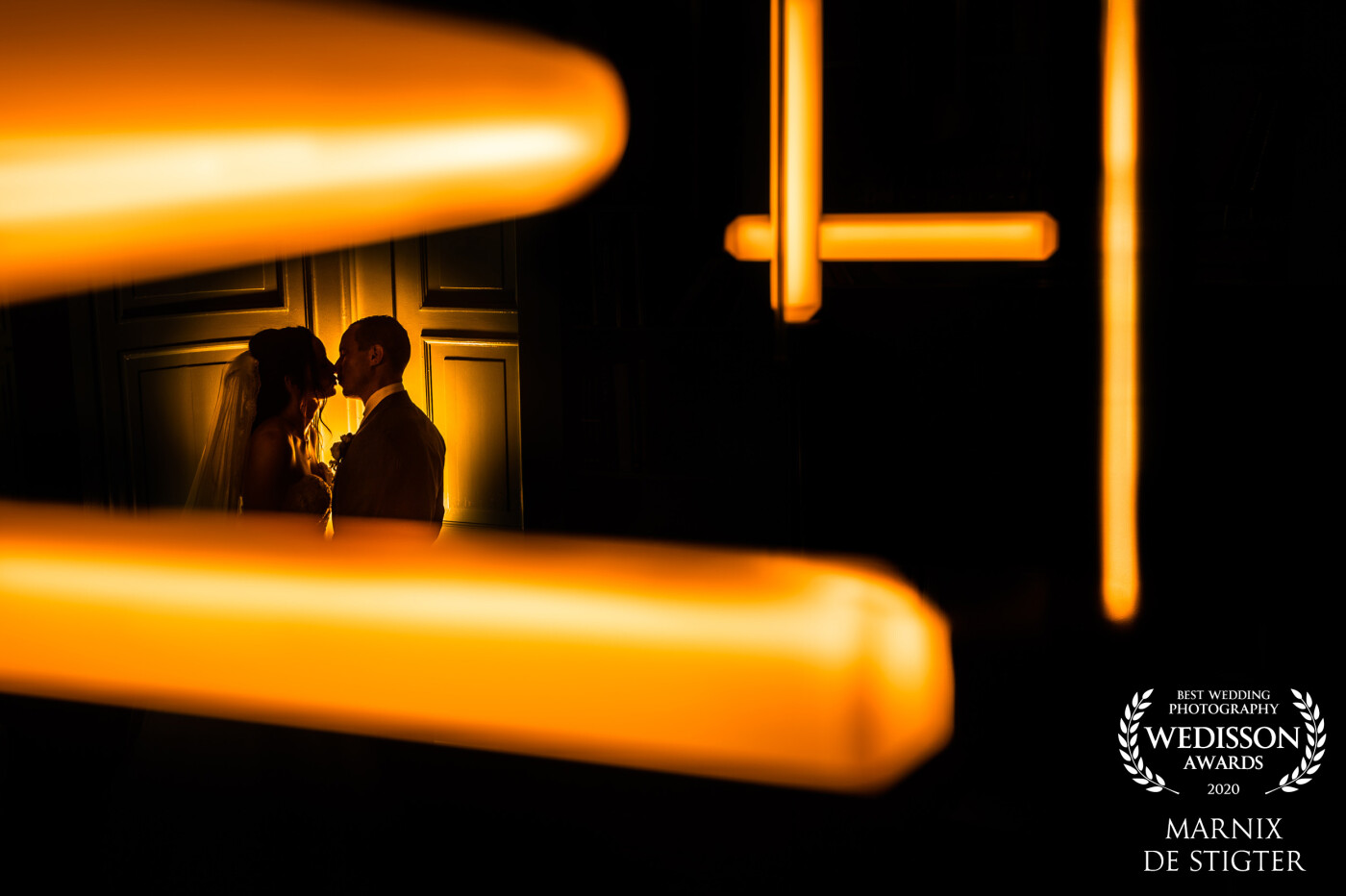 In the old mansion where this couple got married, we found an office with interesting lighting tubes above the table. I instantly knew I wanted to do something with them in an abstract way. I placed the couple with a flash with yellow gel behind them to get this dreamy effect. 