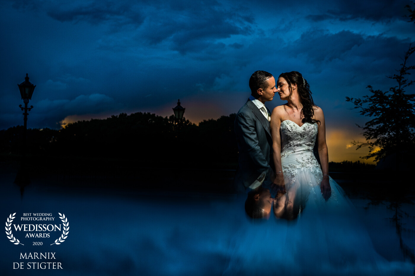 Just a few moments after the sun had set behind the trees we took a moment for some shots which showed the beautiful environment where this couple got married. To emphasize the dramatic blue skies I used a mirrored surface to give the image a more dreamy feel.