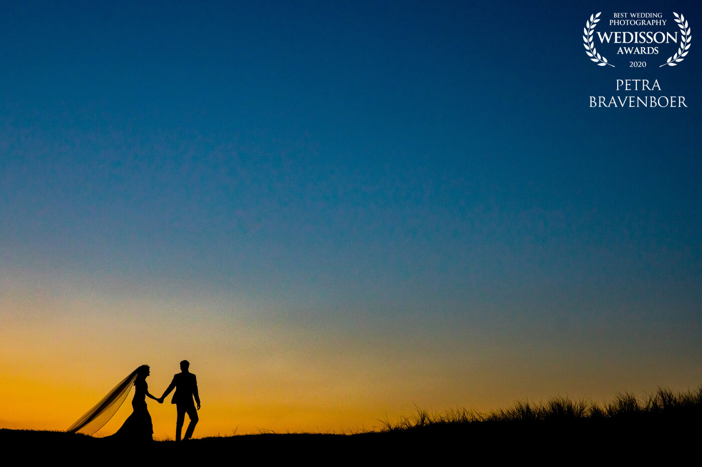 A beautiful September wedding at the beach of Noordwijk. Just after sunset - the party already started - kids were playing on top of the dunes. This wedding couple walked up the dune to the kids and this beautiful silhouette appeared. 
