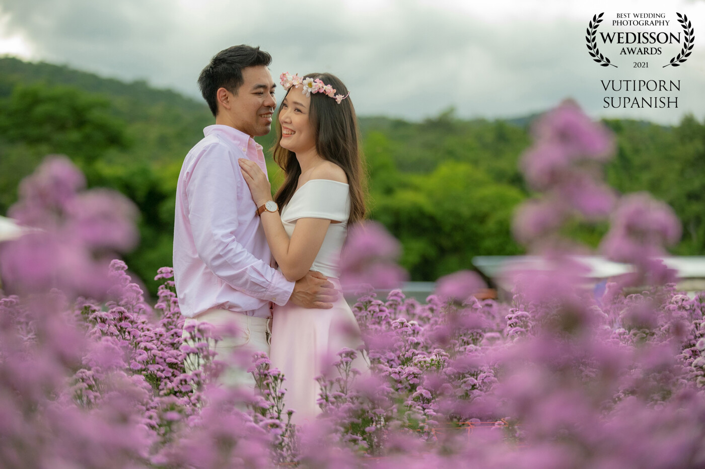 This photo was taken on a field of purple Margaret flowers that begin to bloom. The scene in front of purple corresponds to the mood of the bride and groom smiling happily. I like this picture too.