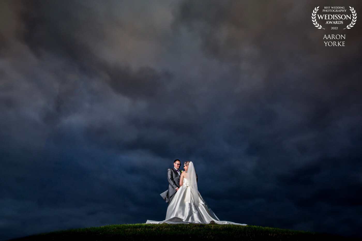 This shot was taken at the Beautiful Forest of Arden in Meriden, Warwickshire. There is a small hill on the golf course where I placed the couple. it was pitch black so to light them up I used a soft box placed to the right of them. I then brought out the sky and the epic clouds in post.
