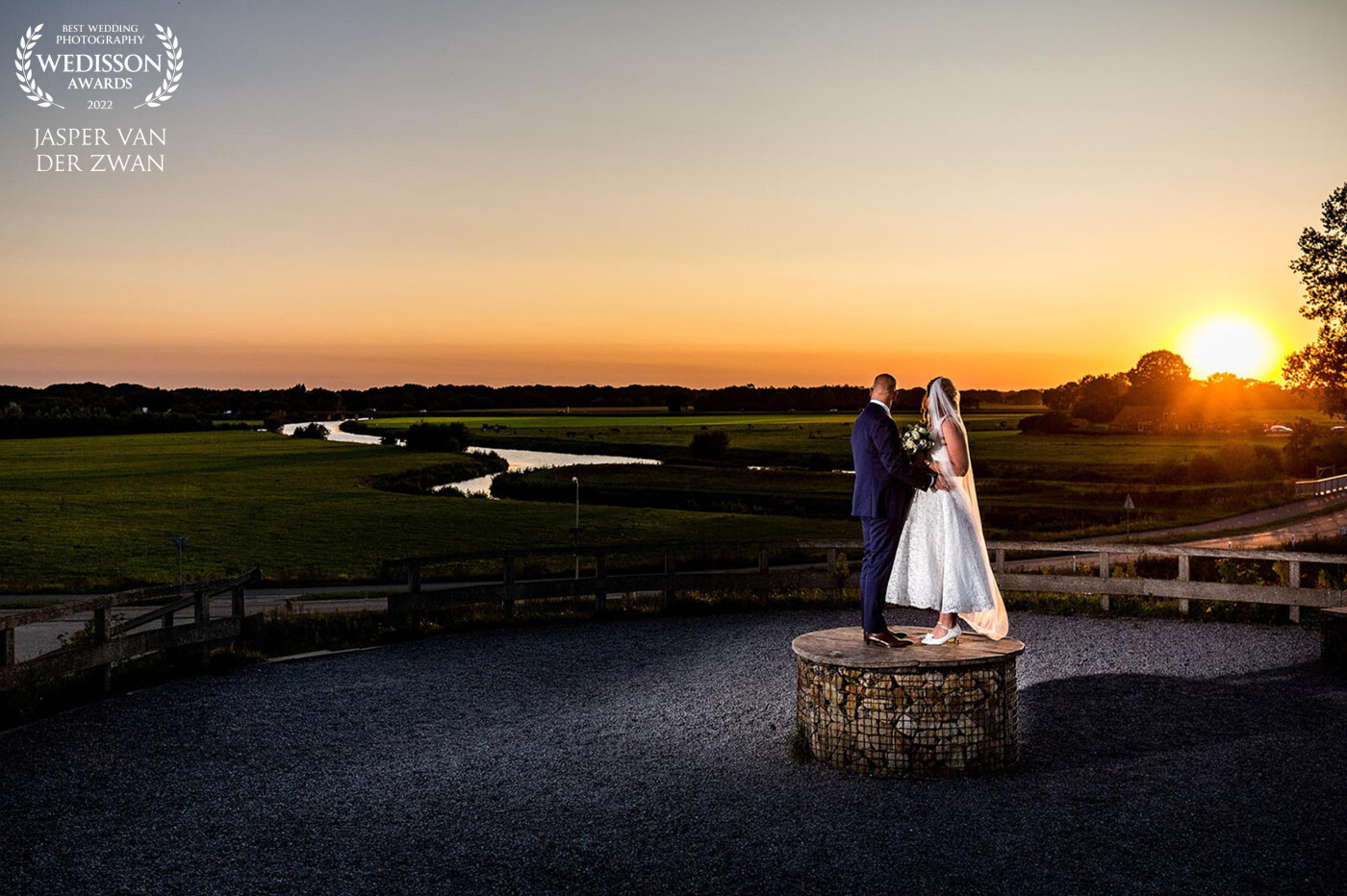 This photo was taken at the Distelberg near Diffelen near the wedding location.<br />
With the river de Vecht, with Overijssel landscape and the sunset in the background.<br />
This makes for me personally the complete wedding photo combined with nature.