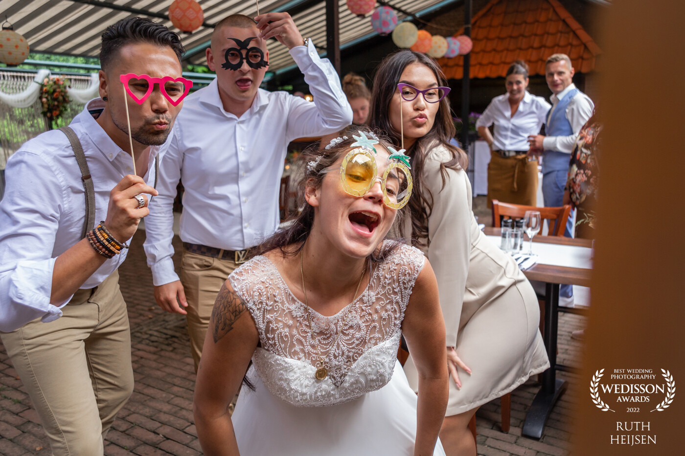 A photo booth at your wedding is always a guaranteed success, especially if some have already been drinking. The reserve disappears and with it the shyness in front of the camera. In this case, the bride, her sister and followers go wild in front of the photo booth and from a distance the groom observes the pleasant scene.