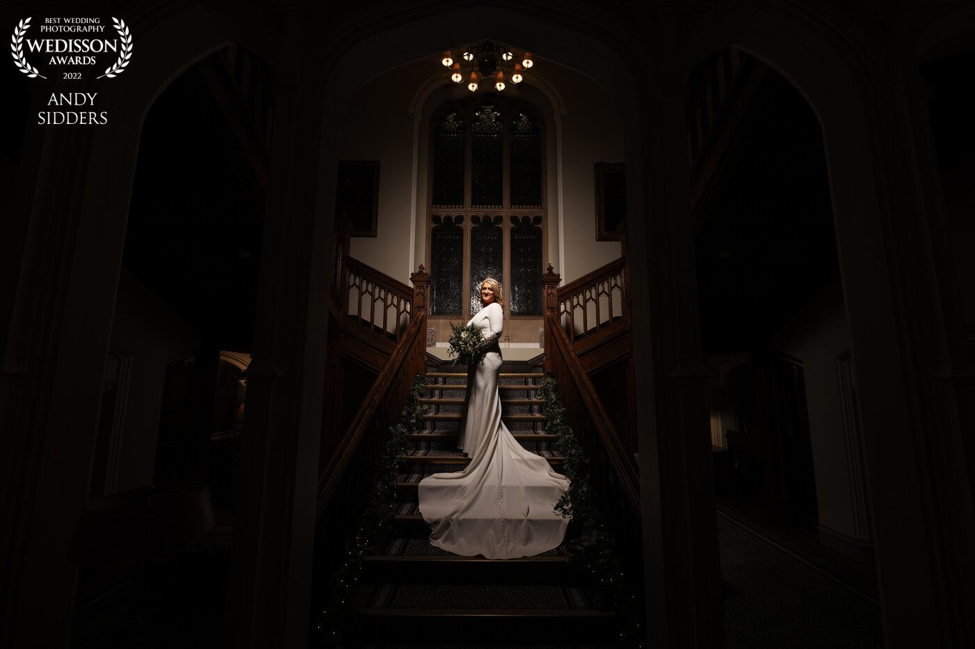 A portrait of the bride taken on the magnificent staircase at De Vere Latimer Estate in Buckinghamshire. The bride was lit by a softbox.