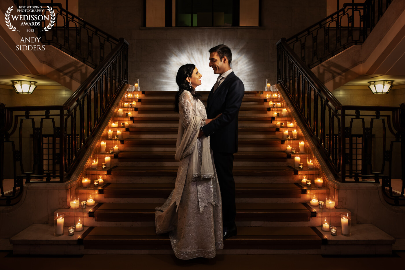 This image was taken at Banking Hall in London. I used a Magbeam to project a light pattern onto the wall at the top of the stairs and lit the couple using flash.