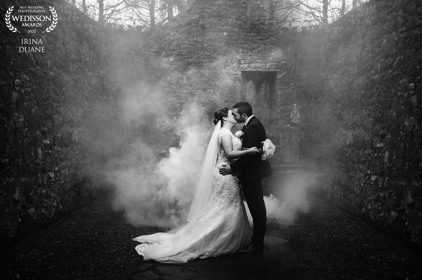 This photograph was taken at St. Patrick's Well in Clonmel, Ireland. We used one godox flash to illuminate the smoke bomb behind the couple and one camera right with MagGrid to control the light spill.