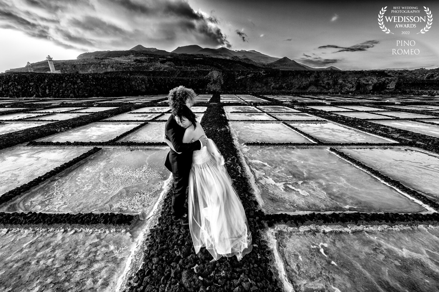 It was a windy day on the southernmost part of the island of La Palma (Canarias). The sun was setting, and our newlyweds were dancing their love away in the salt pans of (Salinas de) Fuencaliente. An ideal setting for an After Wedding session.
