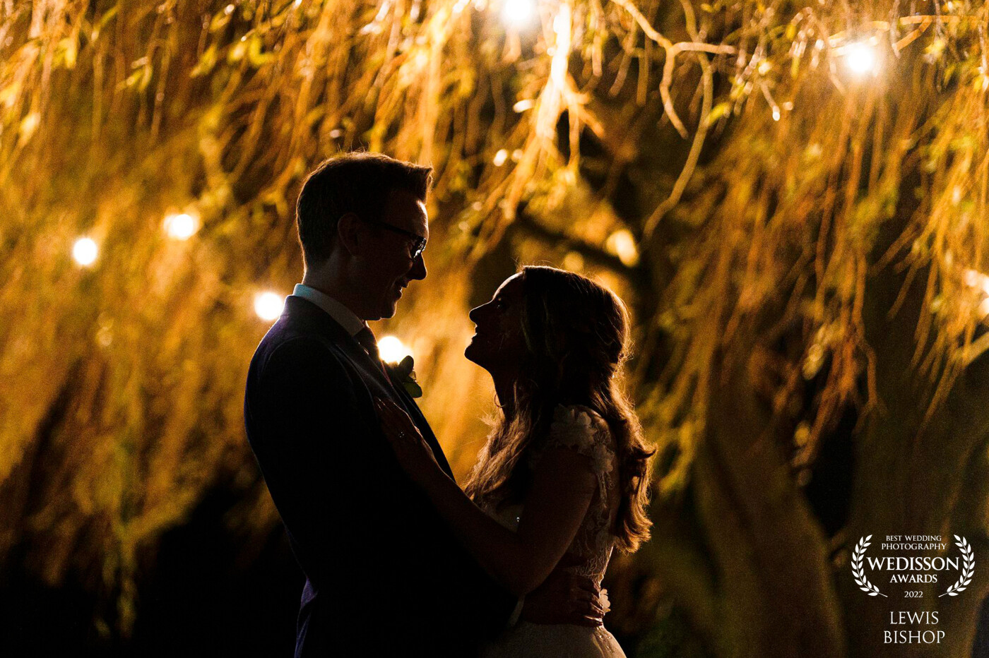 I love to take advantage of available light, and this venue had the most beautiful tree which lit up during the evening! I love the way the bride and groom are silhouetted against the backdrop of the tree.