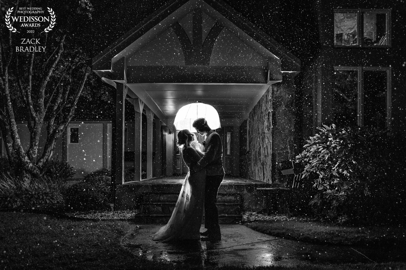 Rain doesn't have to be a bad thing. In fact, it's thought to be good luck if it rains on your wedding day! This backlit image was taken during a lull in the downpour of the day. The bride and groom were awesome and more than happy to go play in the rain!