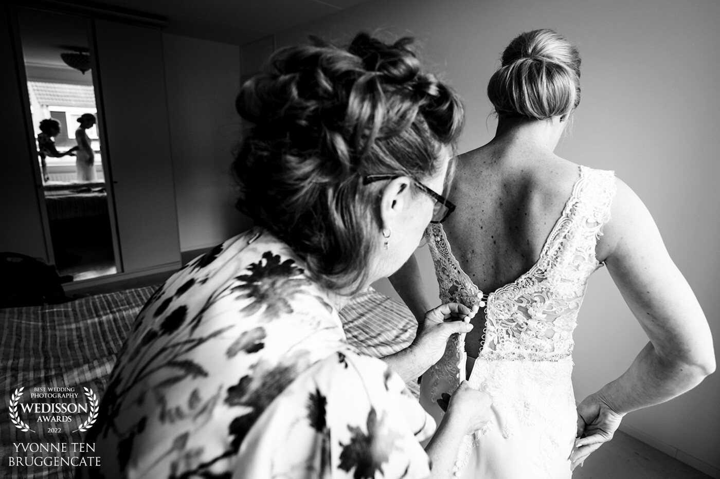 Getting ready in the sleeping room of her parents. Away from the chaotic hair and make-up room. Just some quit time alone for the mother of the bride and het daughter. Such a special moment together!