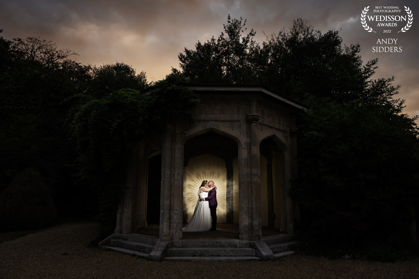 This night time shot was taken at Shendish Manor Hotel in Hertfordshire. I used a Magbeam to project a pattern on the stone gazebo wall behind the couple and lit the couple with flash.