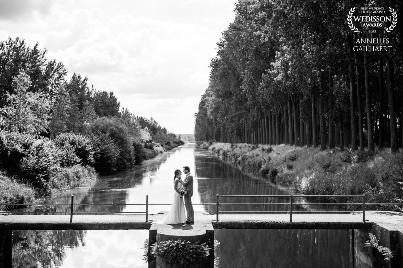 Having a picture in your hometown, is extra special if it's a killer location. The reflection on the water makes the couple stand out even more. The gentle touch of the groom makes the picture complete.