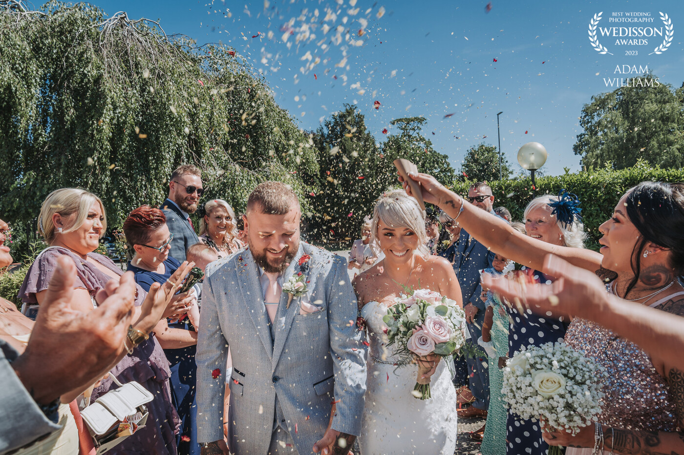 This photo of Sophie & Nathan was taken on the hottest day of the year at Rossett Hall, North Wales. <br />
The blue skies and colourful confetti round off a perfect summers wedding day.