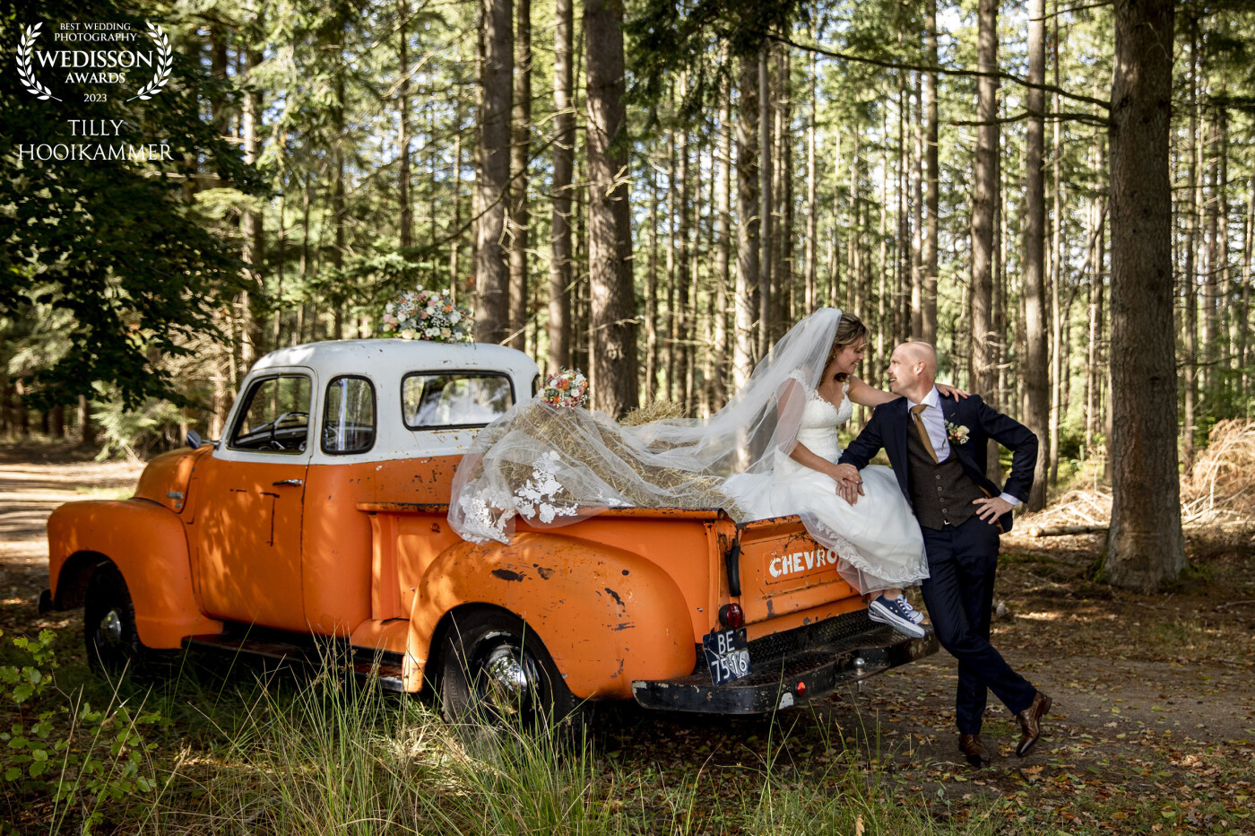 5 minutes before this photo was taken, the bridal couple was still running through the woods. Running from the rain. But as is the case in the Netherlands, the sun immediately shone again and the bridal couple climbed onto the truck. Time for this beautiful picture
