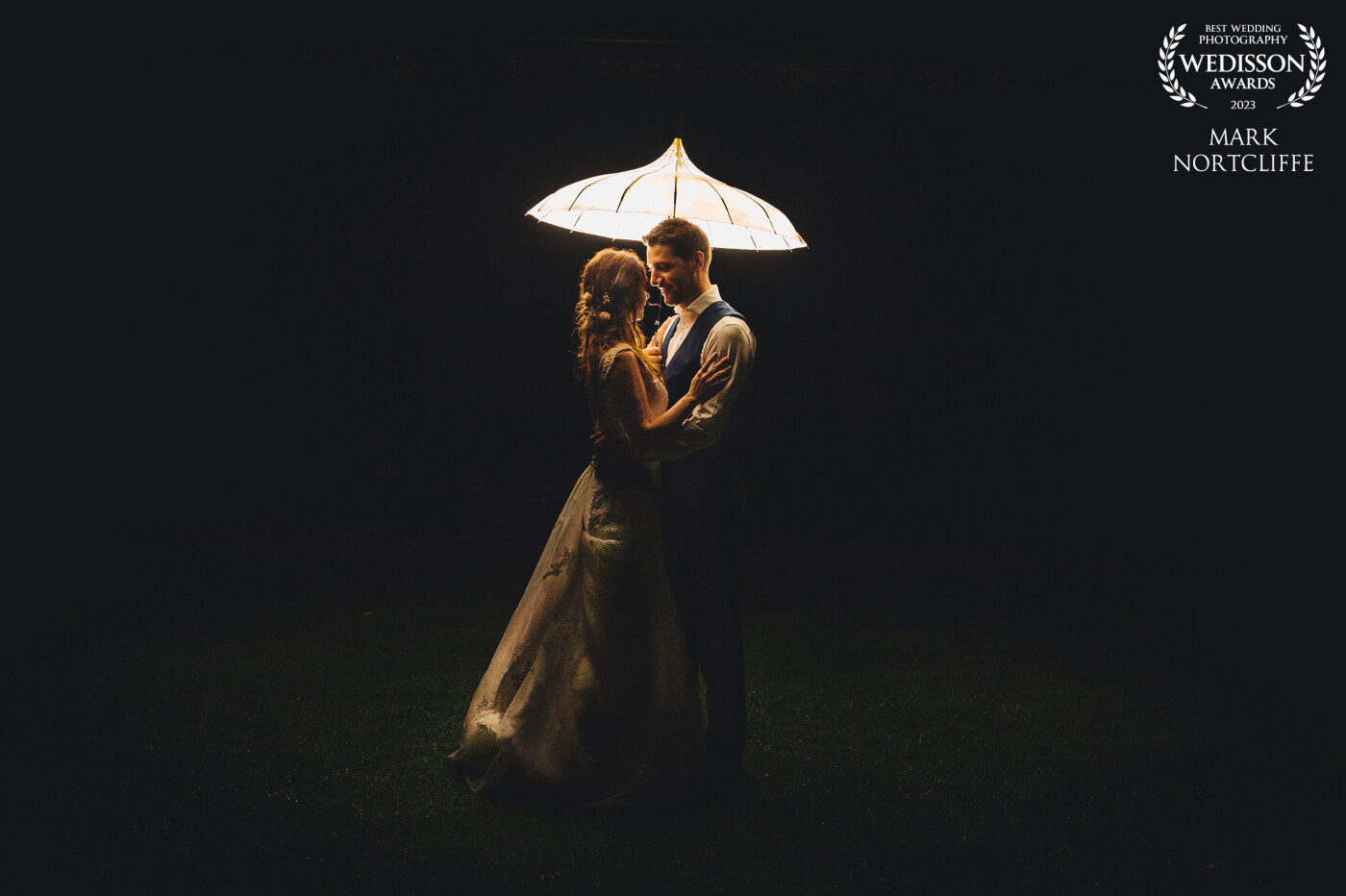This was taken just as I was about to leave the wedding. Taking the opportunity to set up lights beforehand as not to keep the couple from their guests too long. A simple light on a stand behind the couple pointing up into the umbrella casting light down. Love when my couples trust me enough to take time away for shots like this.