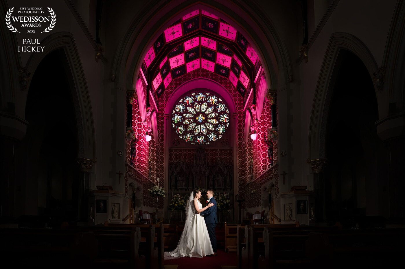 This was a wedding at a beautiful Catholic Church in Stourbridge, West Midlands, UK.<br />
The bride had expressed a wish to go back into the church after the ceremony for some lovely photos. The priest had already turned off all the lights, so I adjusted the ambient settings to expose for the window, then added three flashes, including the magenta-coloured gel, to light the altar.