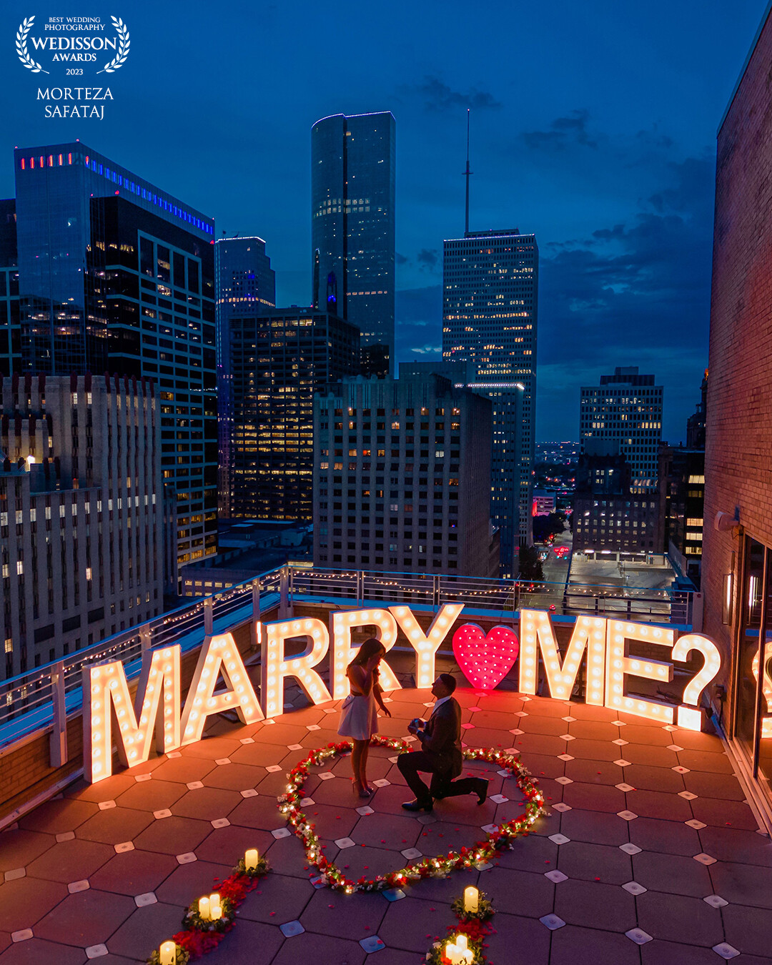 A Captured Moment of Pure Love. <br />
Amidst the enchanting blue hour in downtown Houston, I seized the opportunity to witness and capture a breathtaking surprise proposal. Guiding my drone through the cityscape, I immortalized the magical moment as love filled the air. It was a testament to the power of love and the joy of preserving heartfelt memories. Congratulations to the happy couple Miranda & Javier on this beautiful milestone!
