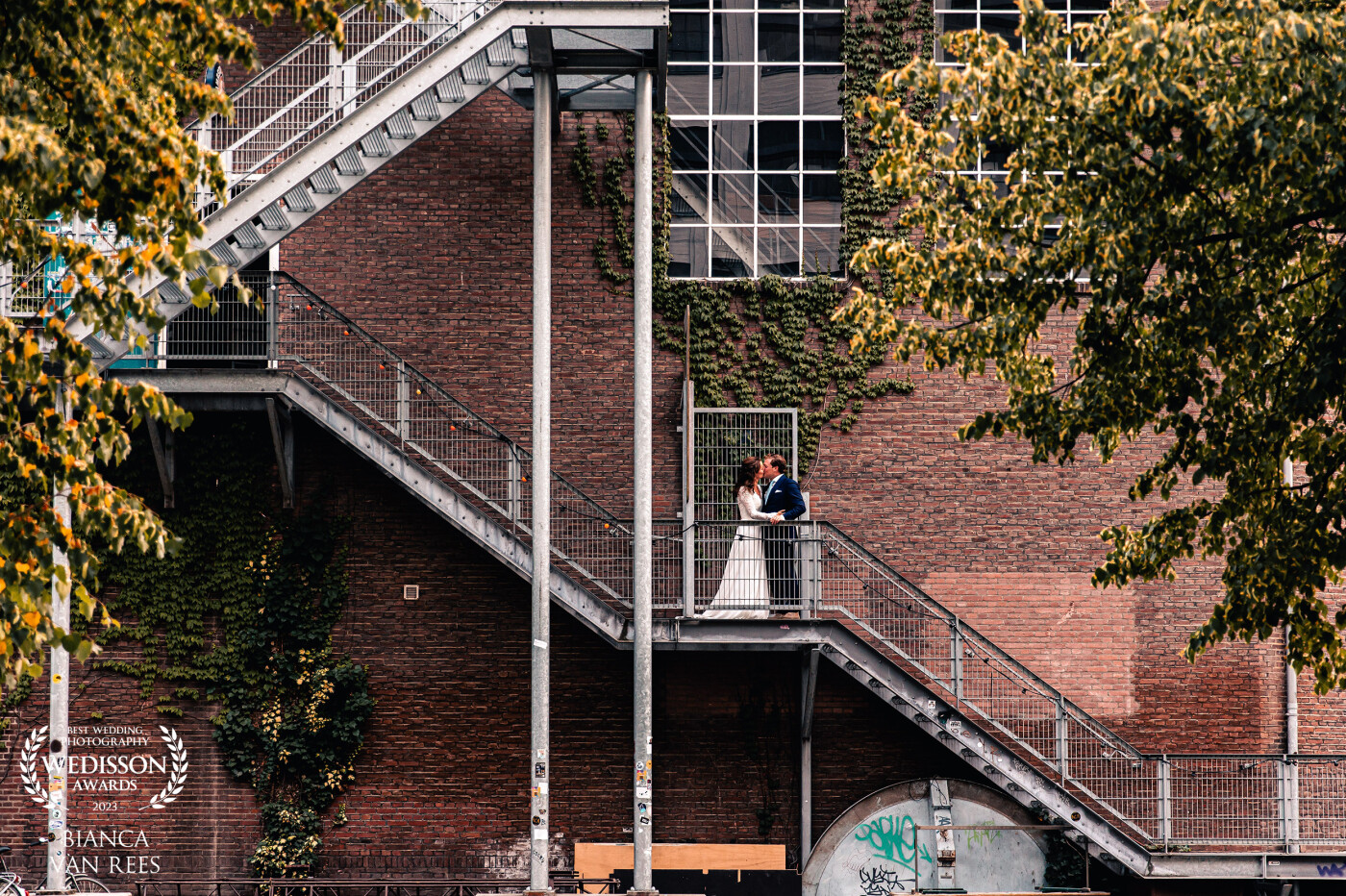 This couple got married at the industrial site Strijp-S. It is a famous area in Eindhoven city (where I live), and the architecture of the buildings is very cool. I knew i wanted to capture this photo, I had it in my head before the wedding, and it turned out so cool! It's all about using the environment to create stunning shots. Nothing more.