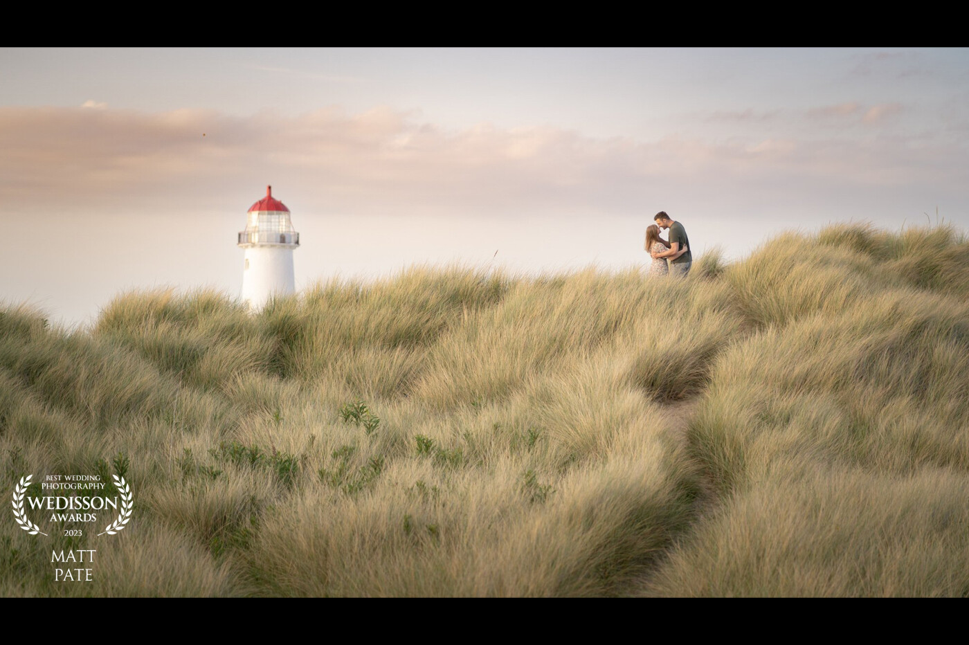 A beautiful sunset walk in the sand dunes for Emma & Rik's pre wedding shoot.<br />
I saw the leading line in the tall grass & the lighthouse in the distance, I thought this would be a great image for the couple to remember this stunning evening by.
