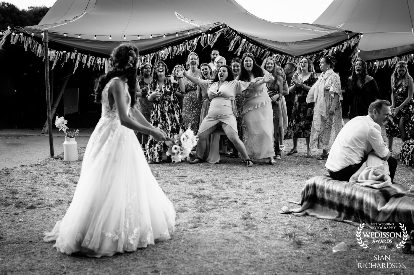 This photo will forever make me smile, the lady in the middle saw the bride was about to throw the bouquet and sprinted from the other side of the field jumping over straw bails to put herself in the centre and push everyone else back ready to catch the bouquet.