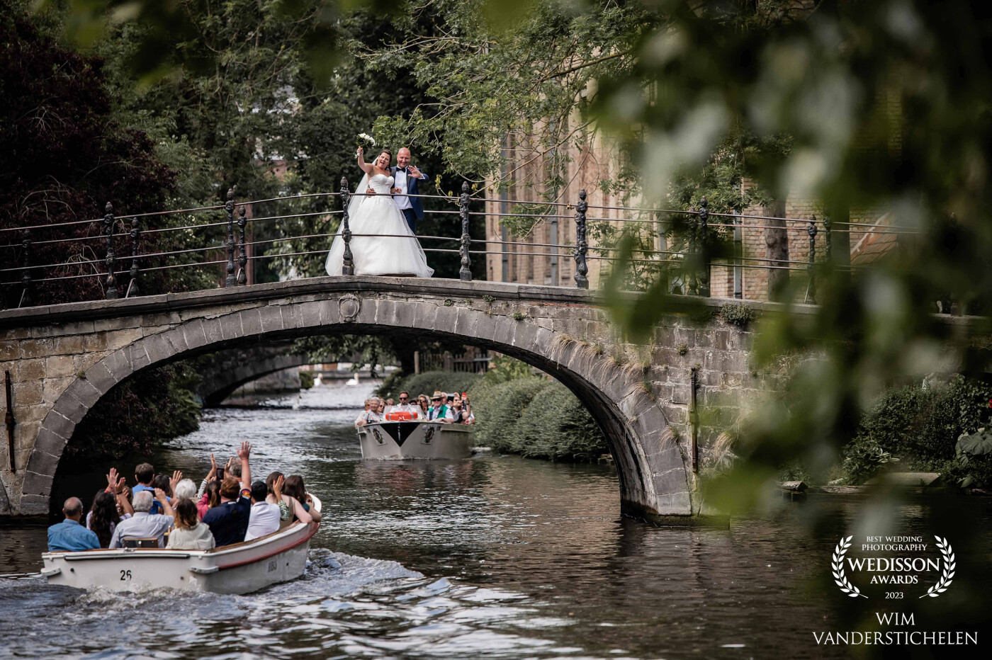 The newlyweds were getting ready to pose for me on a bridge in Bruges, when two boats filled with tourists just passed by waving to them. I knew I had to take a picture of that moment.