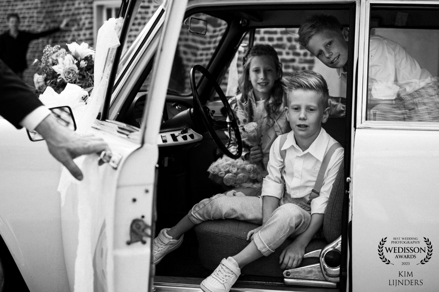The groom opens the door for his children. But actually, they wont come out of the car. It’s too much fun in here!