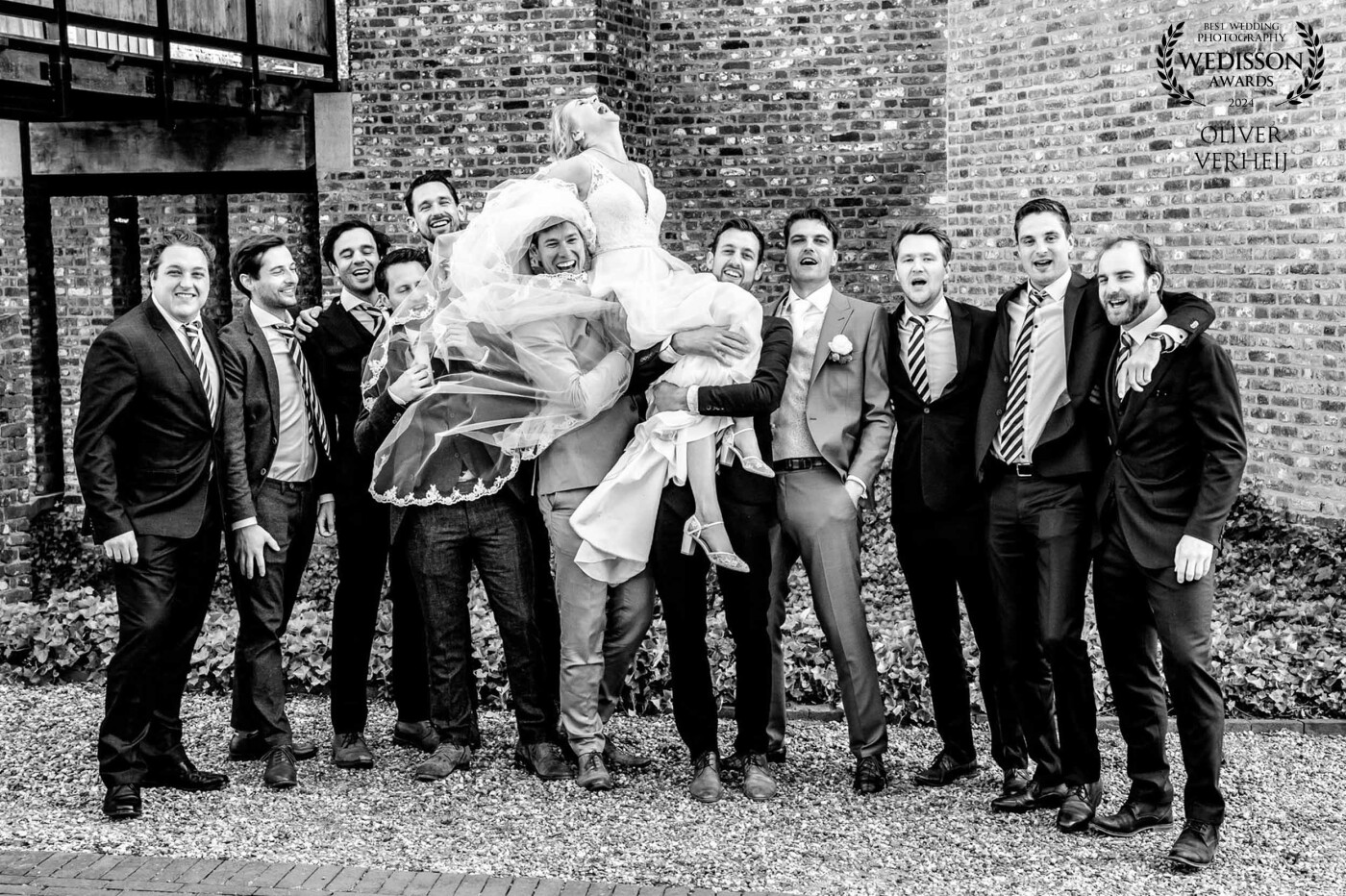 This beautiful bride is having the time of her live during the making of these group photos. She loves being carried by all those men, and it shows!