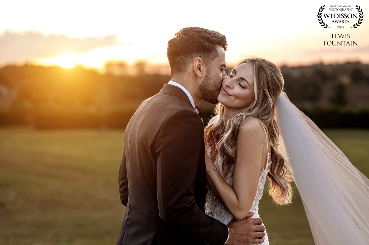 One of those effortless, real moments—just a groom sneaking a kiss on his bride’s cheek while golden hour does its thing. Simple, natural, and full of love.