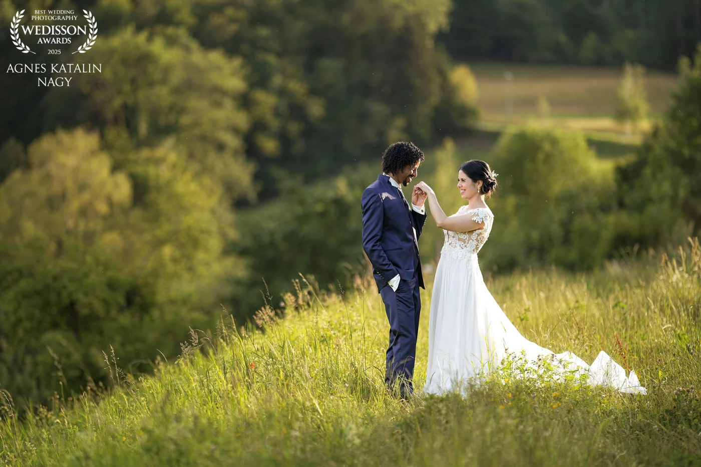 This photo captures a beautiful moment between a Swiss bride and an Eritrean groom on the outskirts of Zürich. The day began with a mix of clouds and sun, and I was concerned we might miss the golden hour. But just before sunset, the sky cleared, revealing a perfect, warm glow. The couple was incredibly adventurous, trusting me enough to follow through tall bushes and into an open field—where we found the perfect spot to capture this cheerful and elegant moment between them.