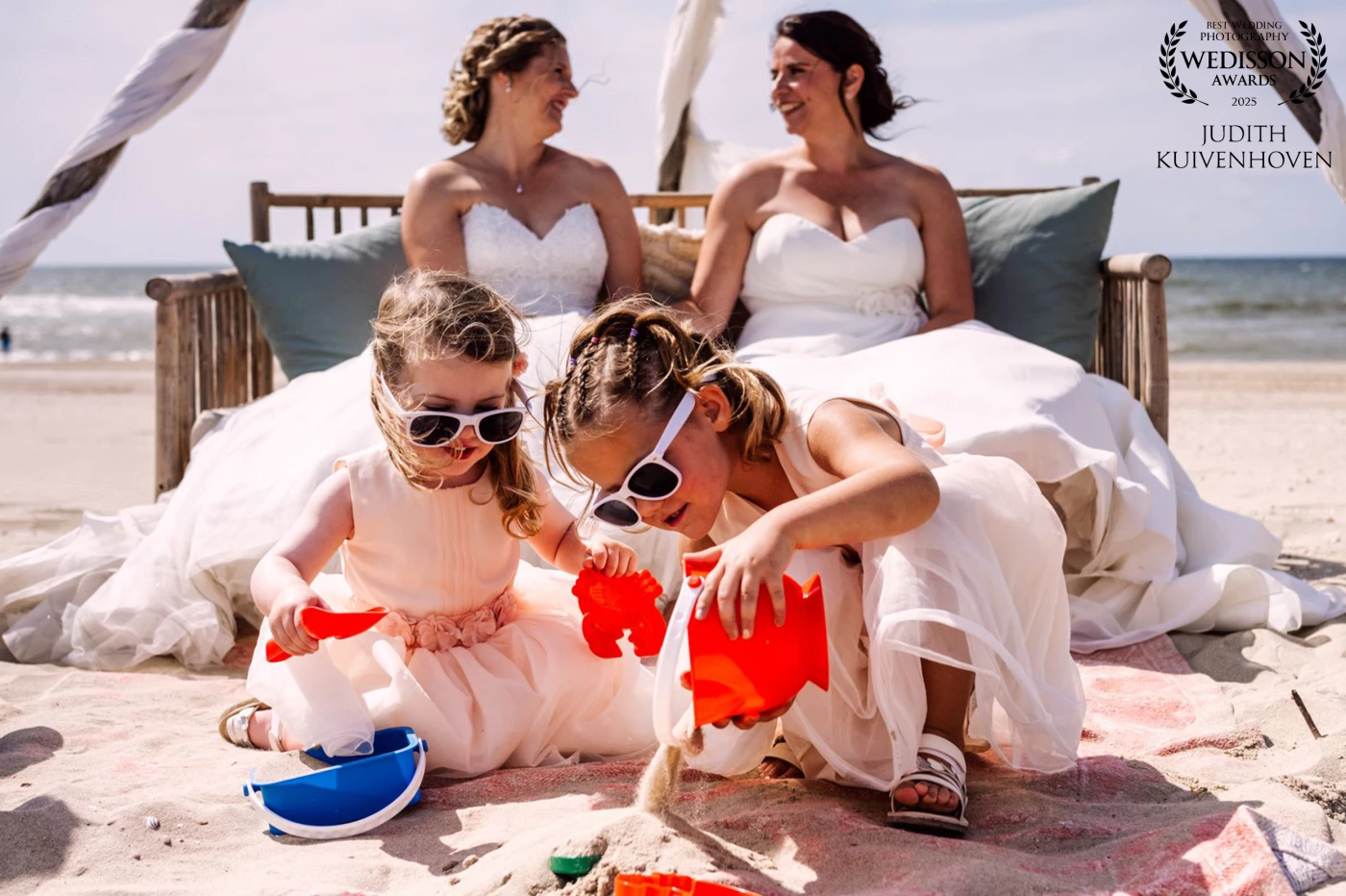 As the ceremony quietly unfolded in the background, a sandy play area kept the flower girls entertained — two parallel stories captured in a single frame