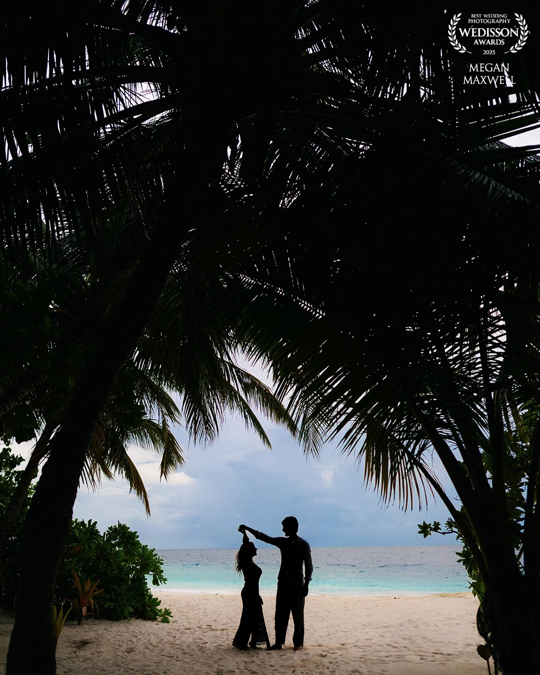 Whilst on holiday with my family, I saw these palm trees creating the most perfect frame. However, I didn't have a couple to put inside of it. A few days later, whilst having a drink at the bar, I noticed Elena and Leonardo. They were exactly the couple I had been hoping to meet. I coyly asked them if they'd like a couples shoot and was thrilled when they agreed. The next evening, we meet on the beach. They spoke hardly any English and I spoke absolutely no Italian, so we got by with enthusiasm and hand gestures. This was the first photo I took of them and I'm still very excited that I managed to get the photo I had envisioned.
