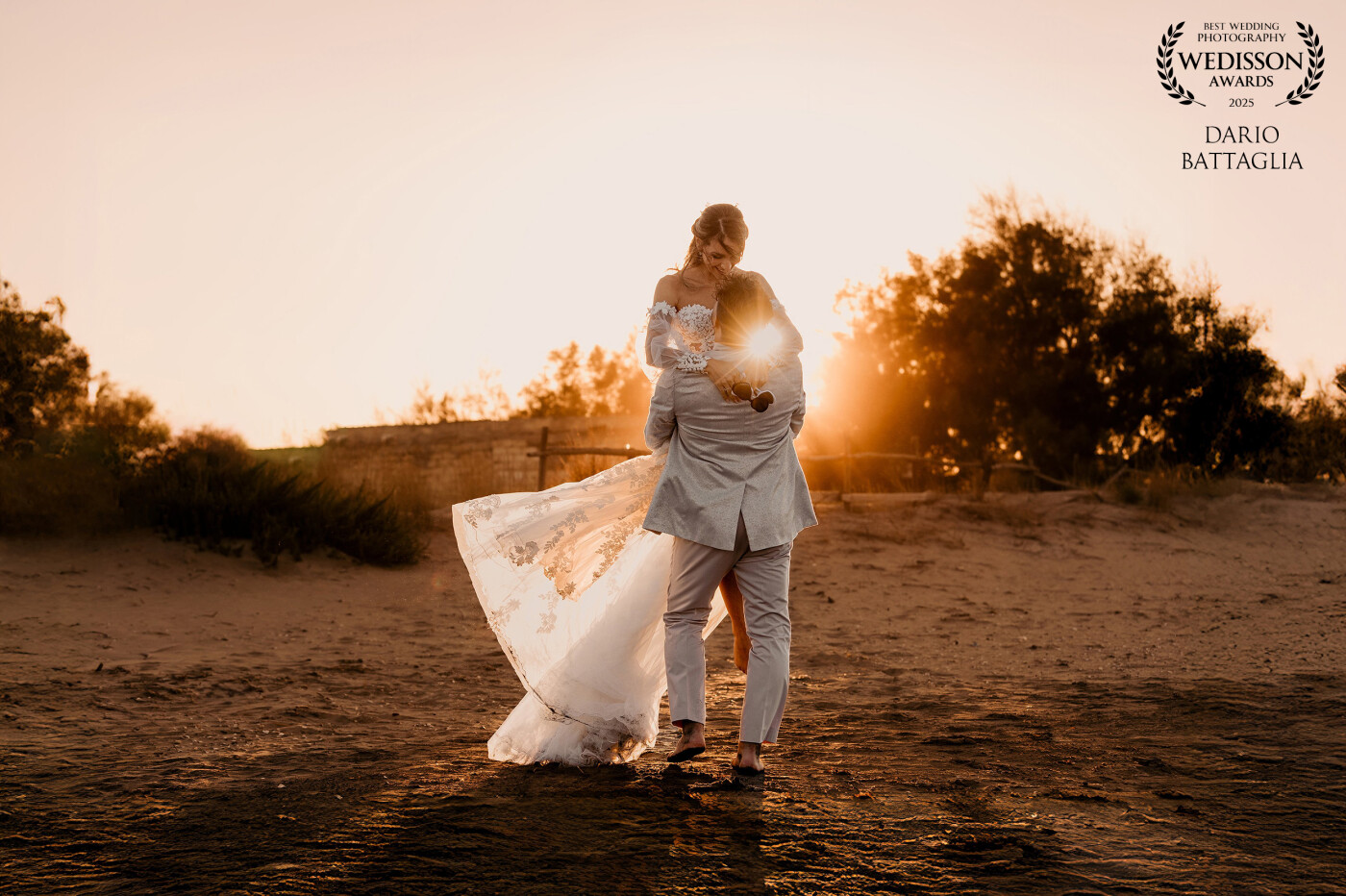 Gli sposi sulla sabbia, ridono come due ragazzini.<br />
Il tramonto li colora, il mare fa da cornice.<br />
In quell’attimo non c’è posa, solo gioia vera.