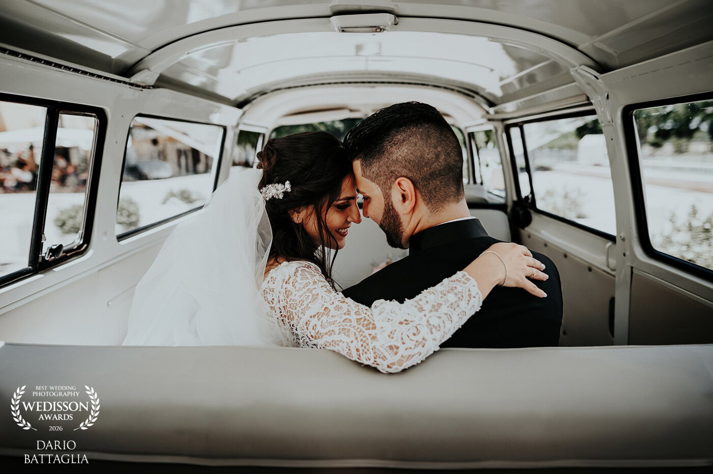 Due sposi seduti sul sedile posteriore di un furgoncino vintage.<br />
Si abbracciano, fronti vicine.<br />
Lei in abito bianco, lui in nero.<br />
Un momento intimo, silenzioso, lontano dal resto del mondo.
