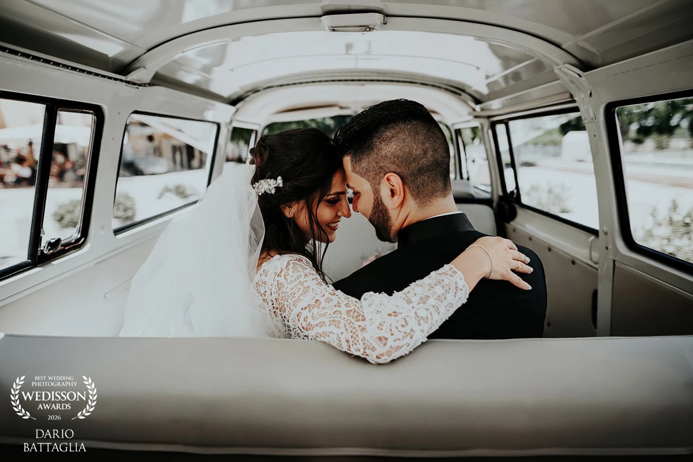 Due sposi seduti sul sedile posteriore di un furgoncino vintage.<br />
Si abbracciano, fronti vicine.<br />
Lei in abito bianco, lui in nero.<br />
Un momento intimo, silenzioso, lontano dal resto del mondo.